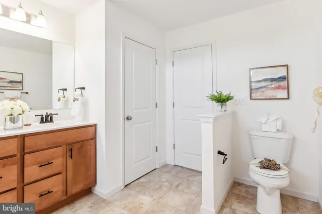 a bathroom with a granite countertop sink a toilet and a shower