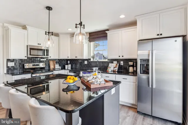 a kitchen with stainless steel appliances granite countertop a sink refrigerator and microwave