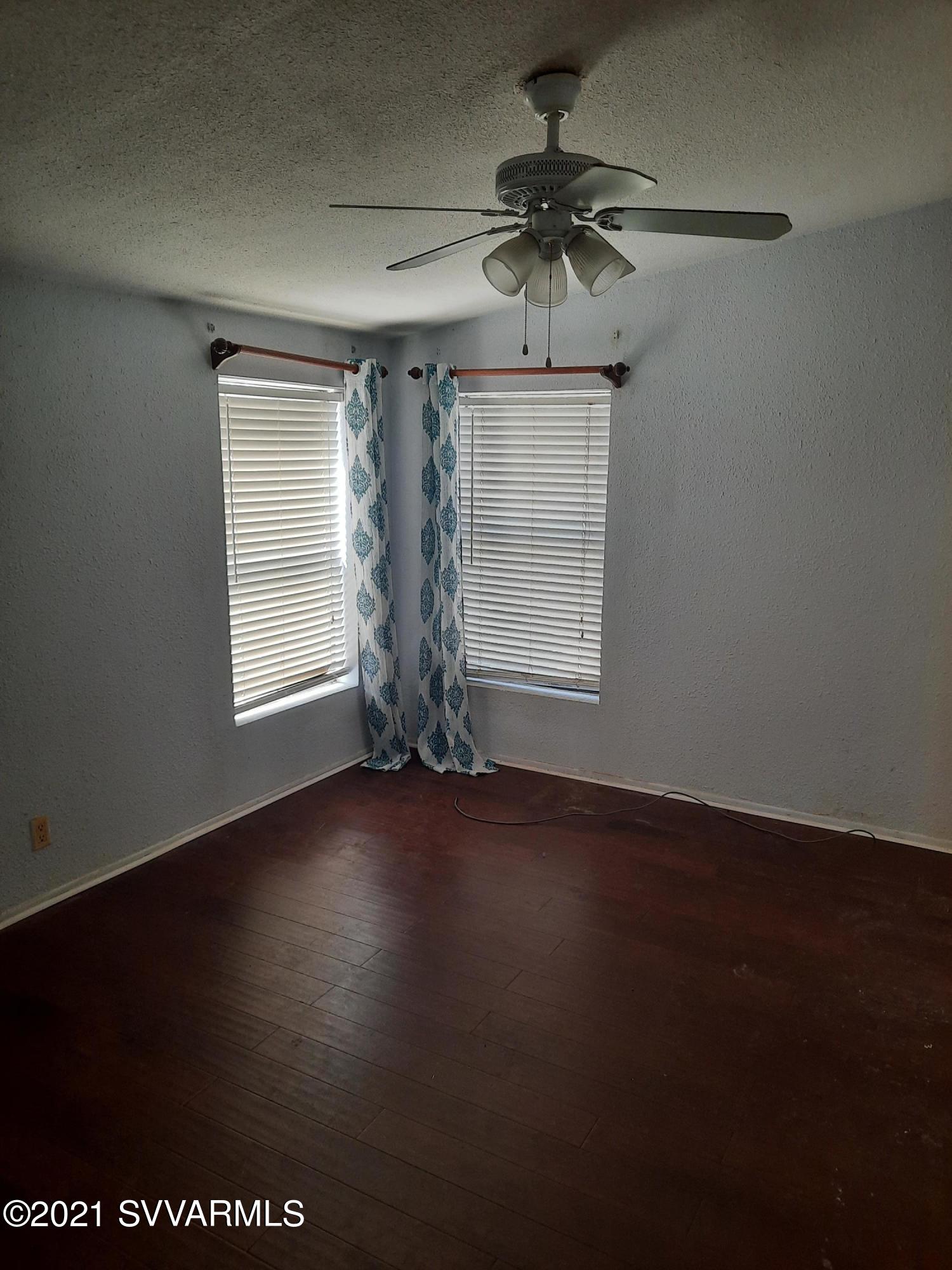 3965 Beaver Lane Rimrock, AZ 86335 - Photo 8 of 10 an empty room with wooden floor fan and windows