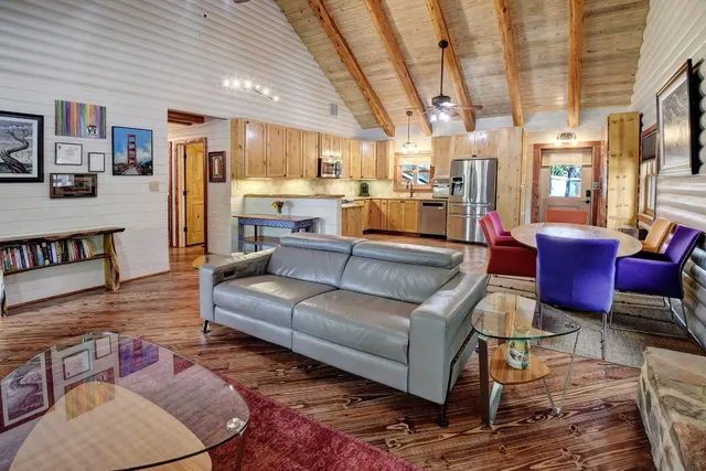 a living room with furniture and a view of kitchen