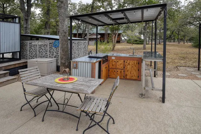 a patio with glass top table and chairs