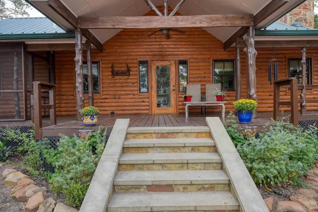 a view of a house with potted plants and a table