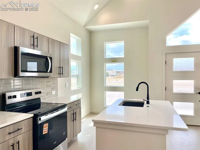 a kitchen with a sink a stove and microwave