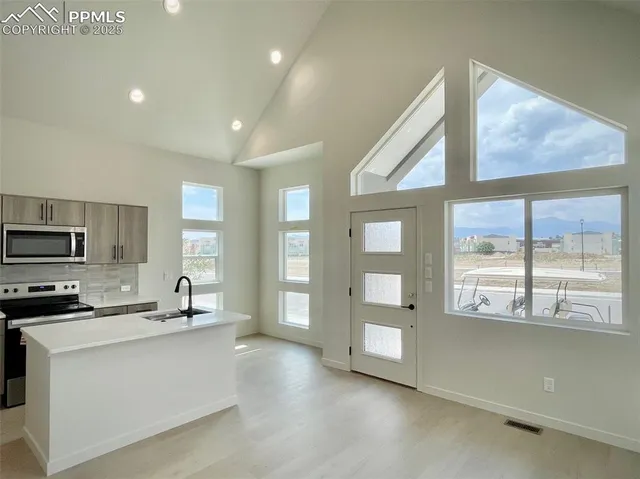 a kitchen with stainless steel appliances kitchen island granite countertop a stove a sink and a refrigerator