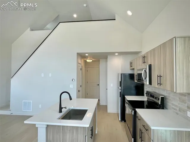 a kitchen with stainless steel appliances a sink and a refrigerator