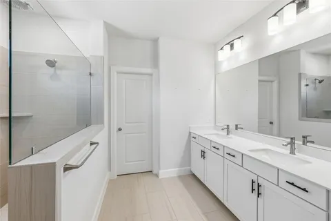 a bathroom with double sink and a mirror