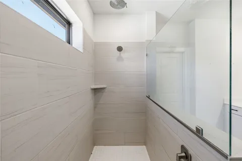 a large white kitchen with wooden floor and stainless steel appliances