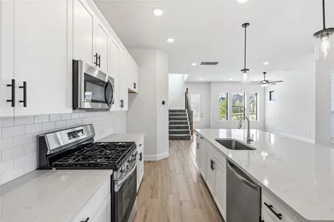 a kitchen with stainless steel appliances a sink stove and cabinets