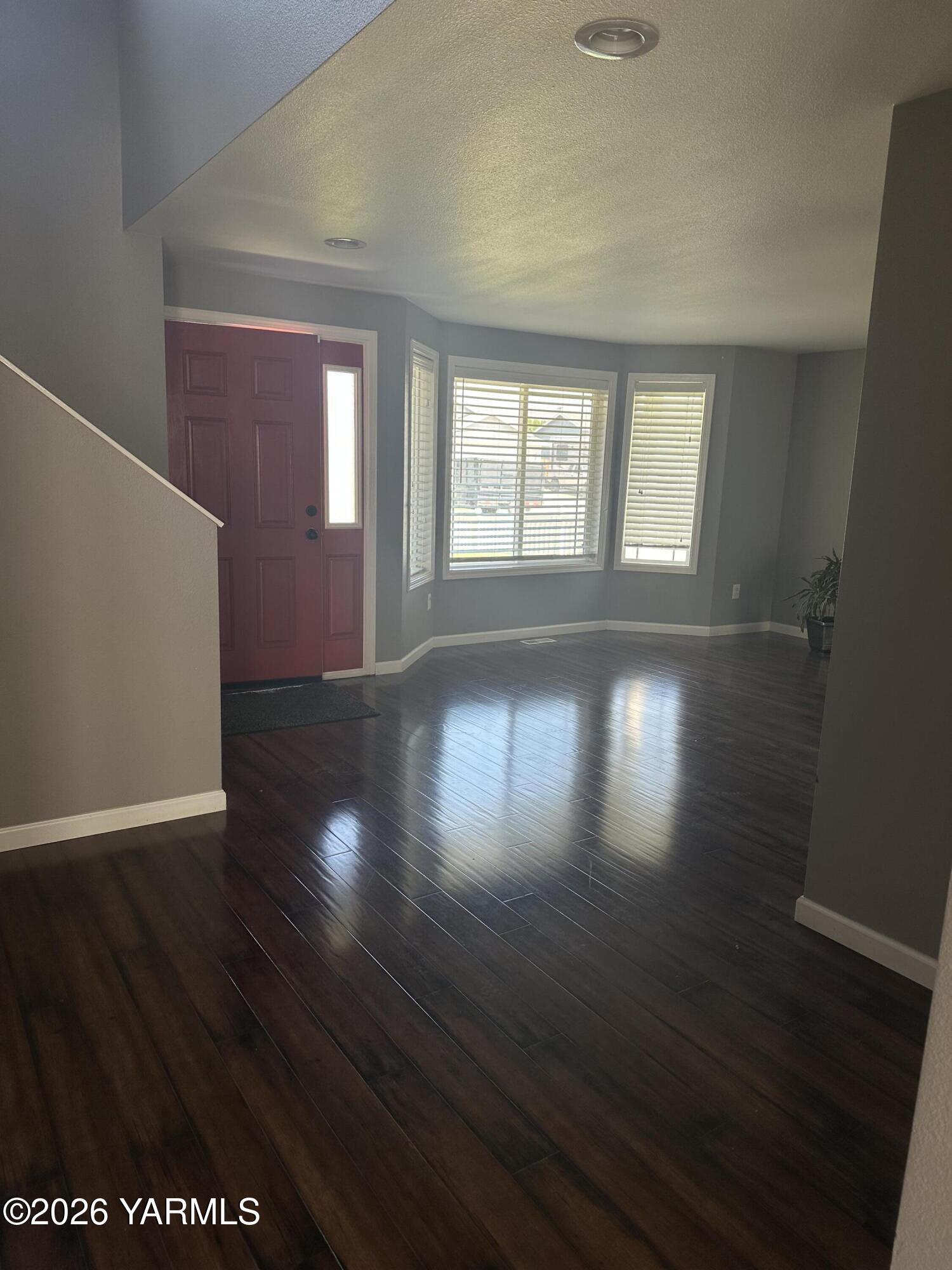 514 Cascade Avenue Moxee, WA 98936 - Photo 5 of 25 a view of an empty room with wooden floor and a window