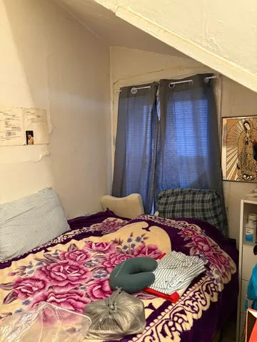 a bedroom with a bed and a potted plant