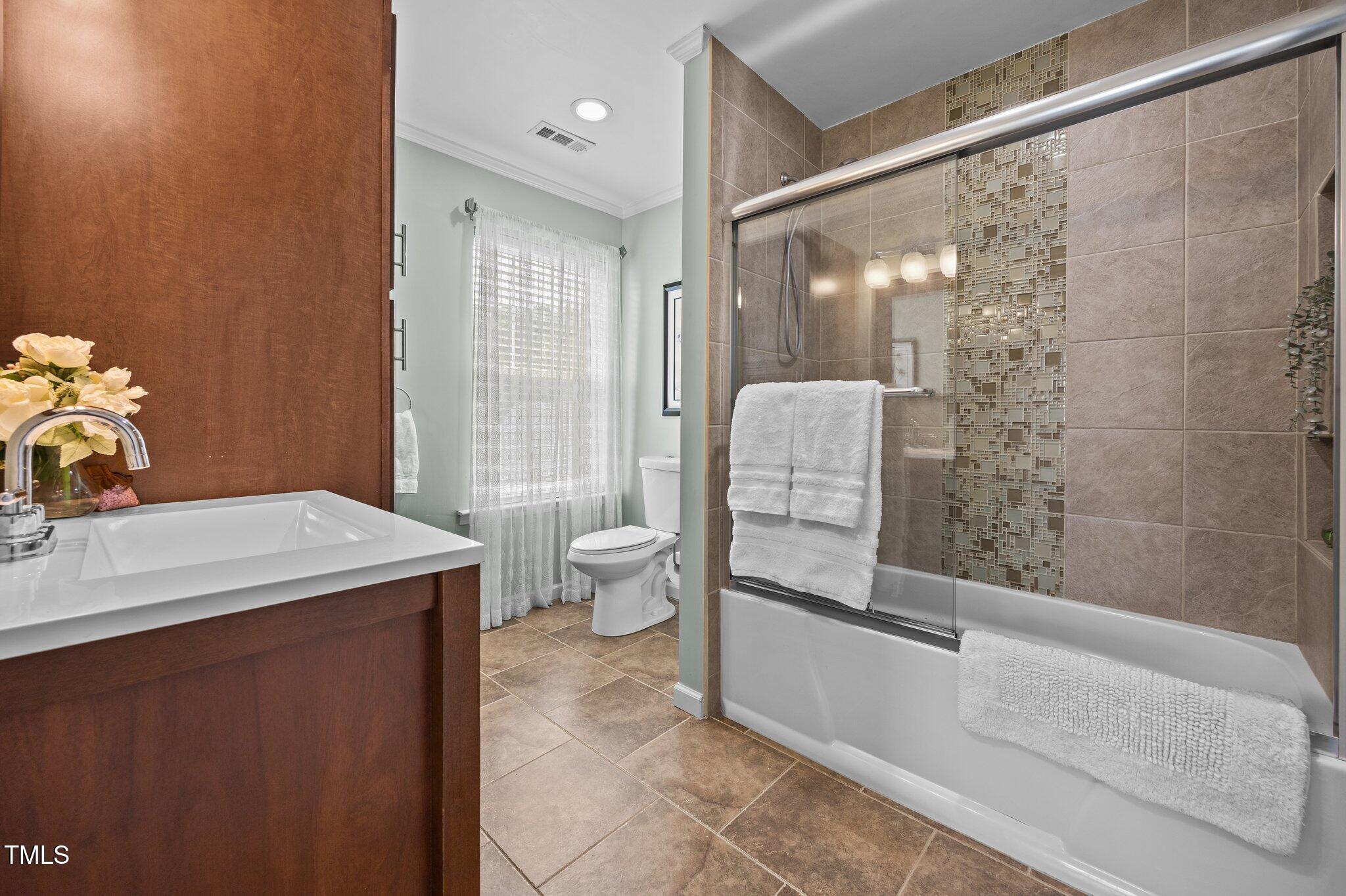 5561 Roan Mountain Place Raleigh, NC 27613 - Photo 11 of 20 a bathroom with a sink a toilet and shower