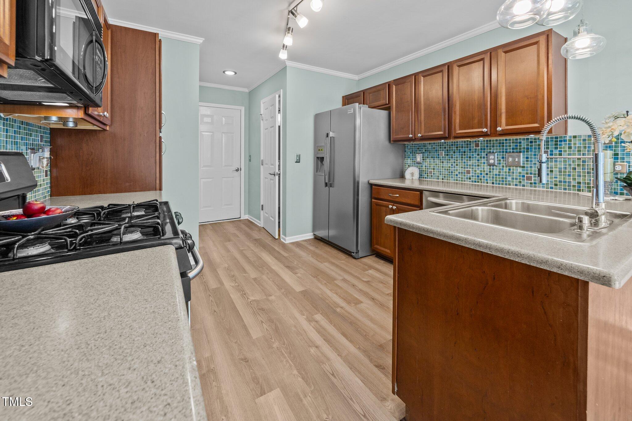 5561 Roan Mountain Place Raleigh, NC 27613 - Photo 4 of 20 a kitchen with stainless steel appliances granite countertop a sink stove and refrigerator