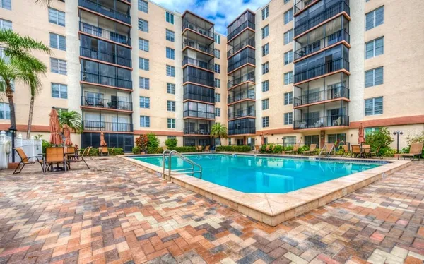 a view of a swimming pool with a lounge chairs in front of a house