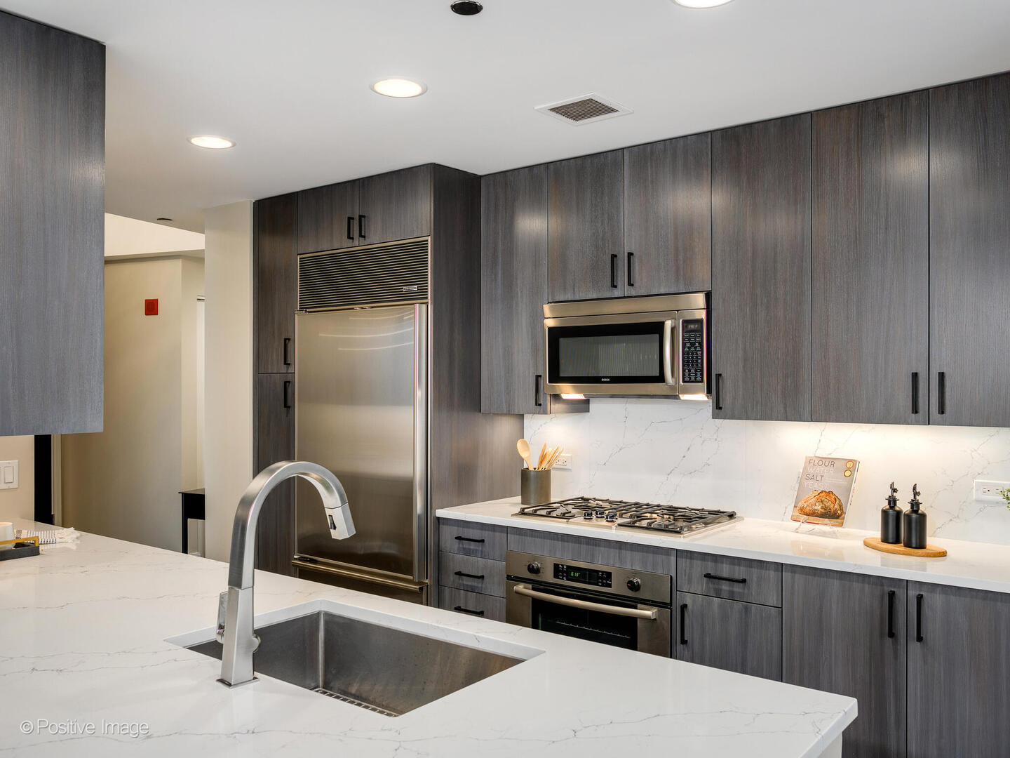 60 East Monroe Street, Unit 2001 Chicago, IL 60603 - Photo 11 of 68 a kitchen with stainless steel appliances kitchen island granite countertop a refrigerator and a stove top oven