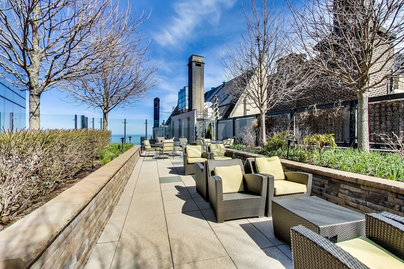 60 East Monroe Street, Unit 2001 Chicago, IL 60603 - Photo 39 of 68 a view of a patio with couches table and chairs with wooden fence and plants