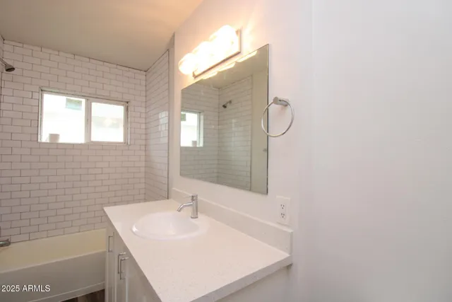 a bathroom with a sink mirror and a bathtub