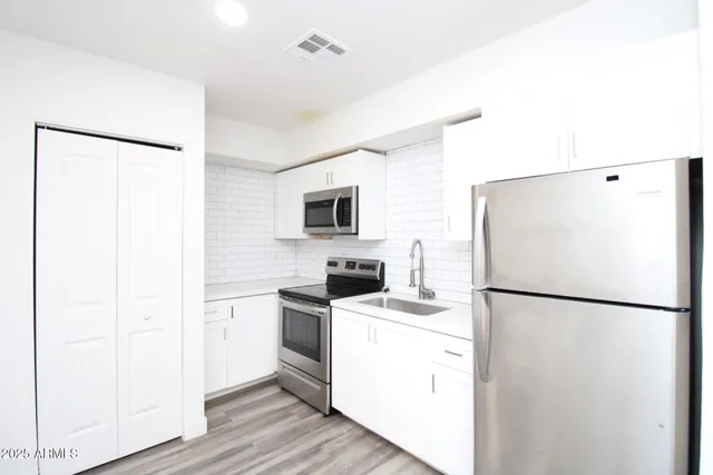 a white refrigerator freezer and a stove sitting inside of a kitchen