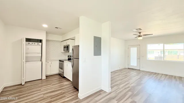 a view of a kitchen with a refrigerator a ceiling fan and wooden floor