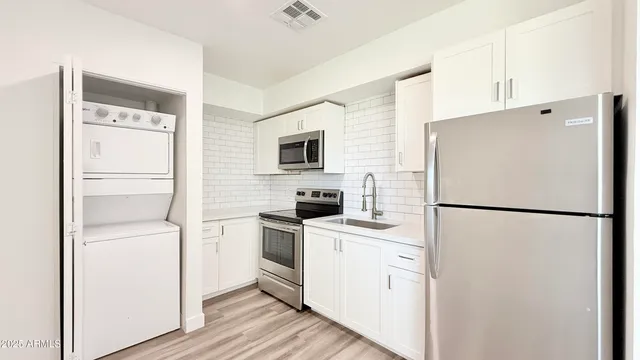 a white refrigerator freezer and a stove sitting inside of a kitchen