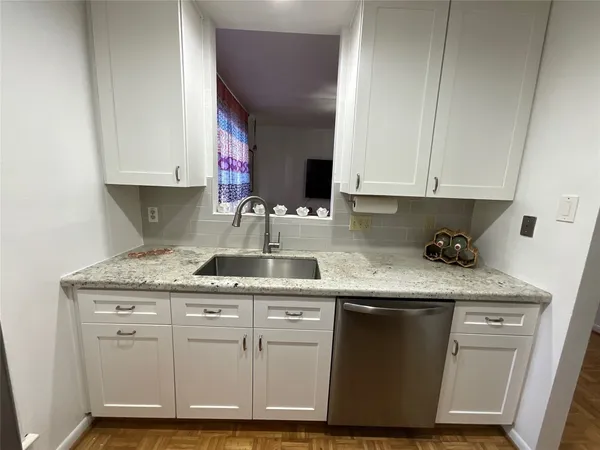 a kitchen with granite countertop stainless steel appliances a sink stove top oven and cabinets