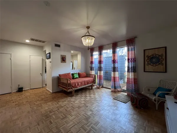 a spacious bedroom with a bed a chandelier and a window
