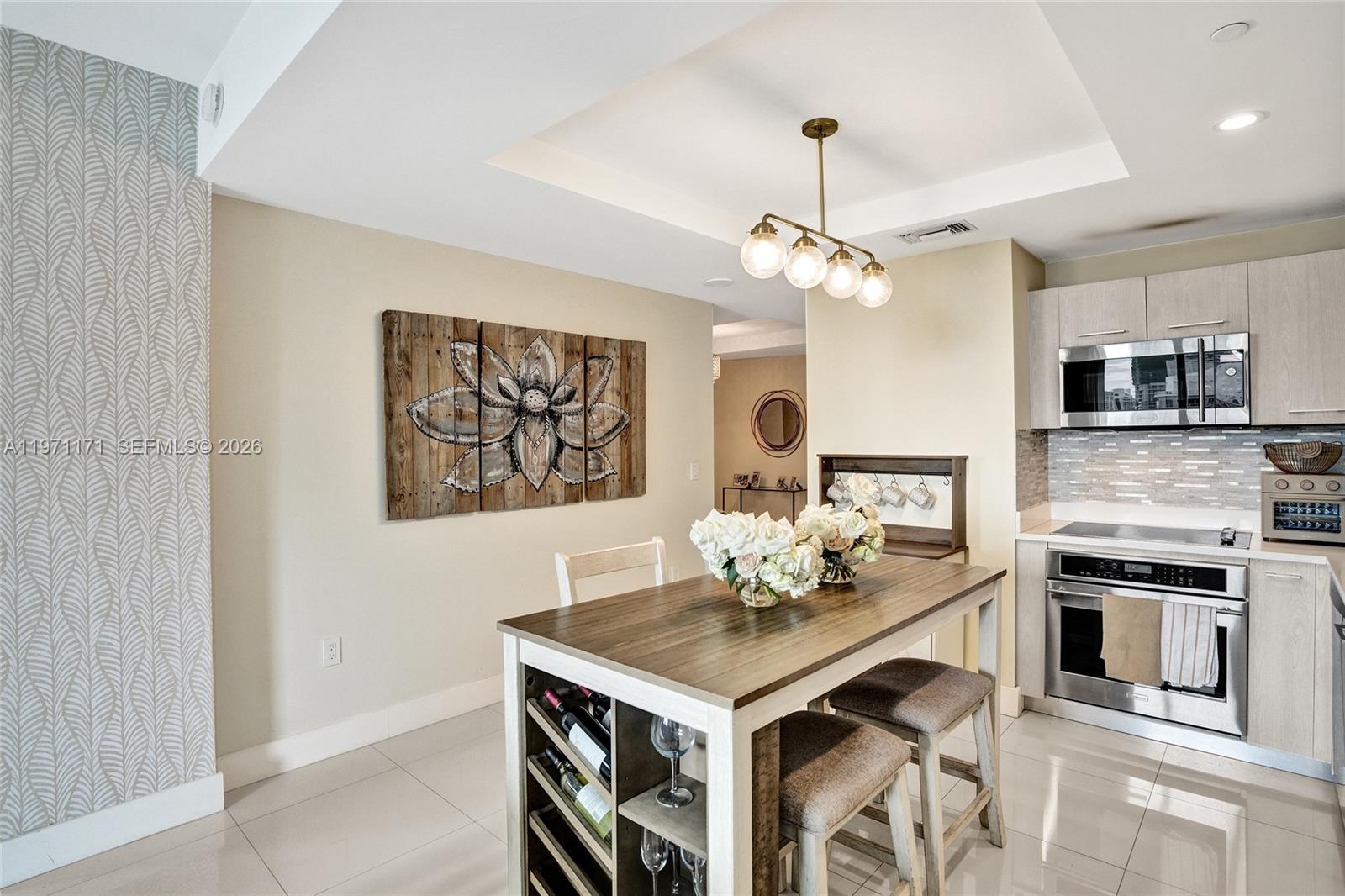 45 Southwest 9th Street, Unit 4004 Miami, FL 33130 - Photo 6 of 28 a kitchen with stainless steel appliances a kitchen island a stove a table and chairs in it