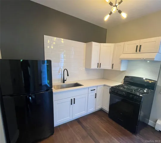 a kitchen with a sink a refrigerator and cabinets