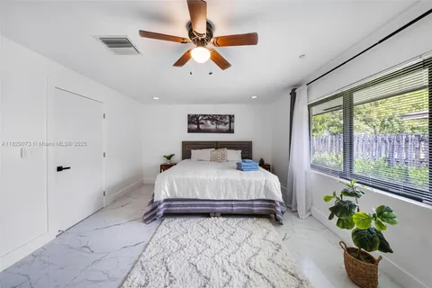 a bedroom with a bed and a large window