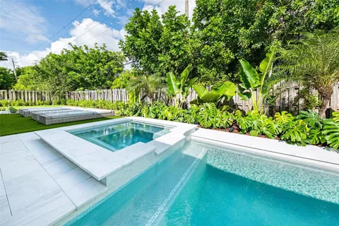 a view of a swimming pool with a yard and plants