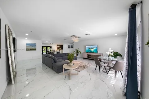 a living room with furniture and a view of kitchen