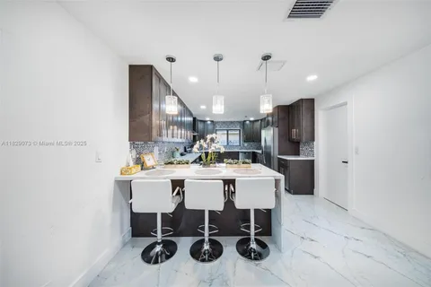 a kitchen with a dining table chairs appliances and cabinets