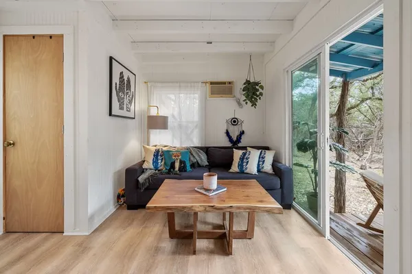 a living room with furniture wooden floor and a large window