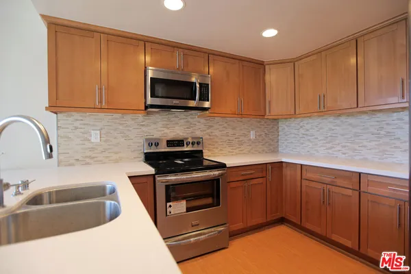 a kitchen with stainless steel appliances granite countertop a sink stove and microwave
