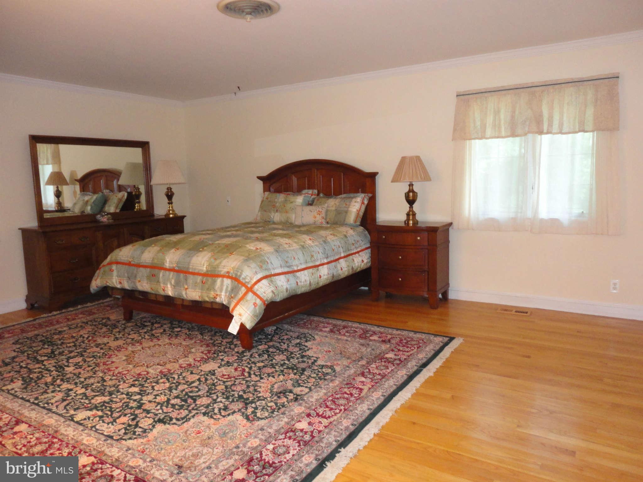 12915 Gent Road Reisterstown, MD 21136 - Photo 16 of 29 a bedroom with a bed and a dresser next to a window