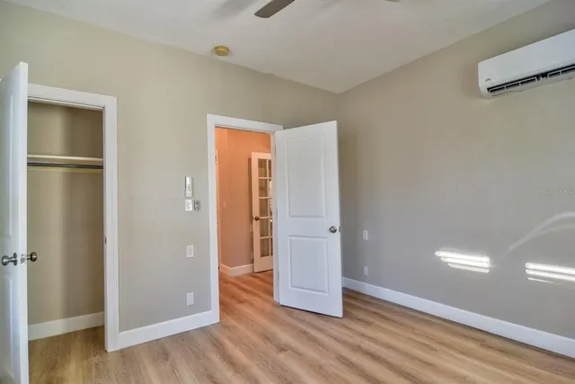 a view of a hallway with wooden floor and closet