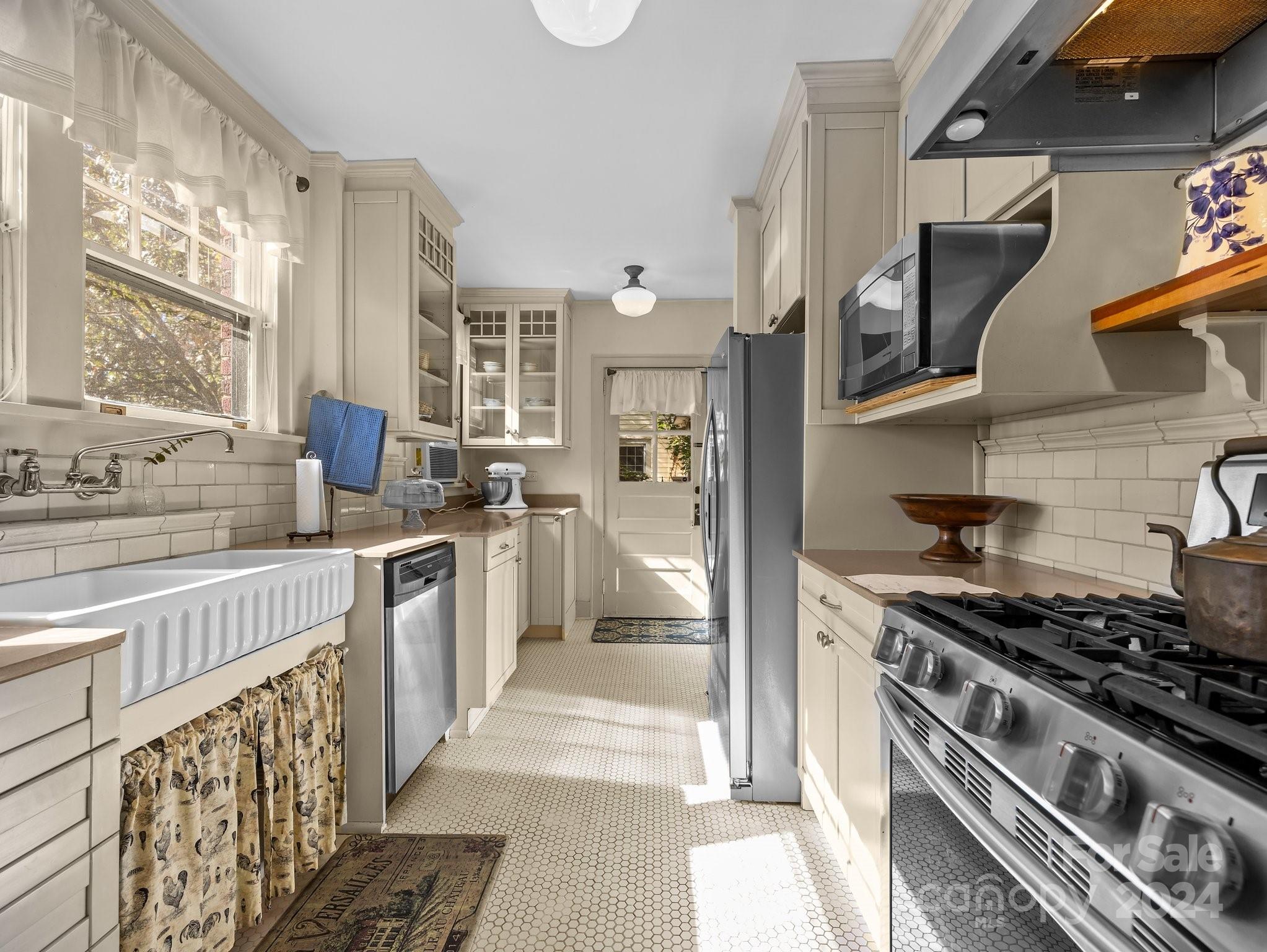 100 Edwin Place Asheville, NC 28801 - Photo 14 of 35 a kitchen with stainless steel appliances a stove a sink and a refrigerator