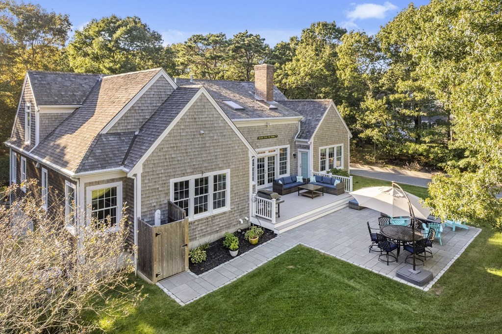 90 Howes Path Dennis, MA 02638 - Photo 37 of 42 a view of a white house with a chairs and table in a patio