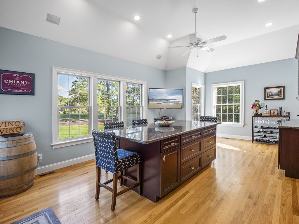 90 Howes Path Dennis, MA 02638 - Photo 6 of 42 a kitchen with granite countertop a stove a sink dishwasher and a dining table with wooden floor