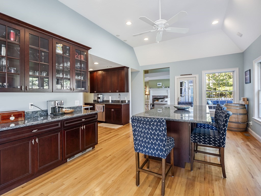 90 Howes Path Dennis, MA 02638 - Photo 8 of 42 a kitchen with a stove a sink dishwasher a dining table and chairs with wooden floor