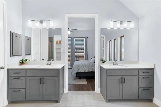 a spacious bathroom with a double vanity sink a large mirror a bathtub and