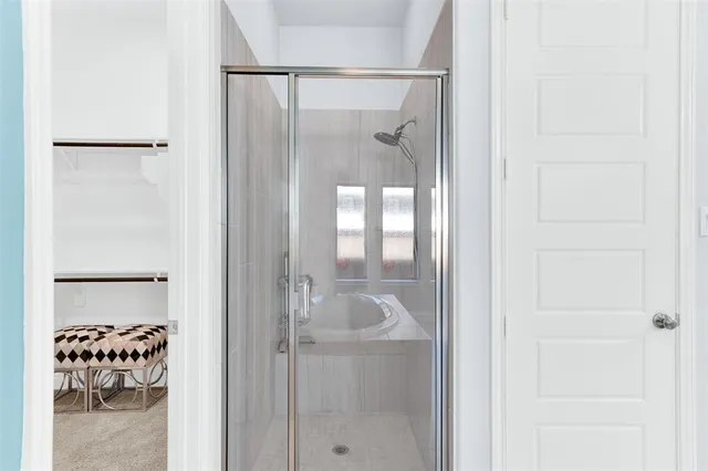 a bathroom with a glass shower door and a window