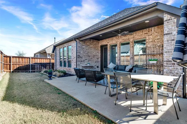 a view of backyard with large trees and wooden fence