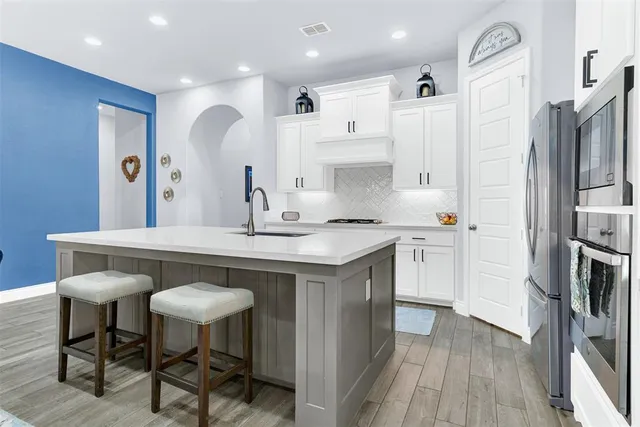 a kitchen with stainless steel appliances a sink stove and refrigerator