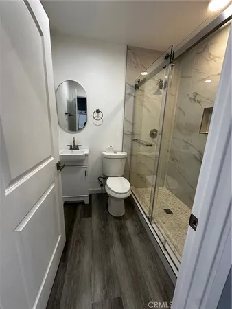 a bathroom with a sink a toilet a mirror and shower