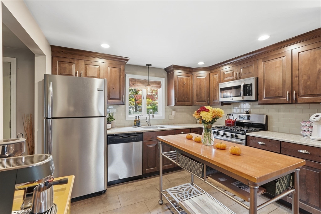 32 Pennsylvania Avenue Springfield, MA 01118 - Photo 14 of 41 a kitchen with a refrigerator a microwave a sink and chairs
