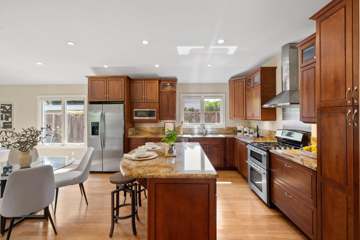 1030 Ashley Place Mountain View, CA 94040 - Photo 14 of 32 a kitchen with stainless steel appliances granite countertop a stove top oven a sink dishwasher a dining table and chairs with wooden floor