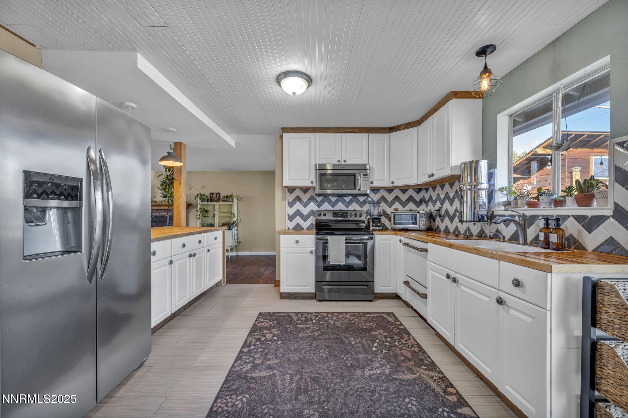 1100 Mission Circle Reno, NV 89503 - Photo 17 of 61 a kitchen with granite countertop a refrigerator and a stove top oven