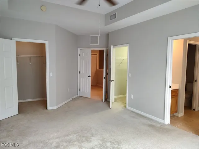 an empty room with closet and a hallway