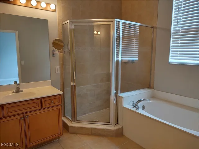 a bathroom with a granite countertop sink and a bathtub