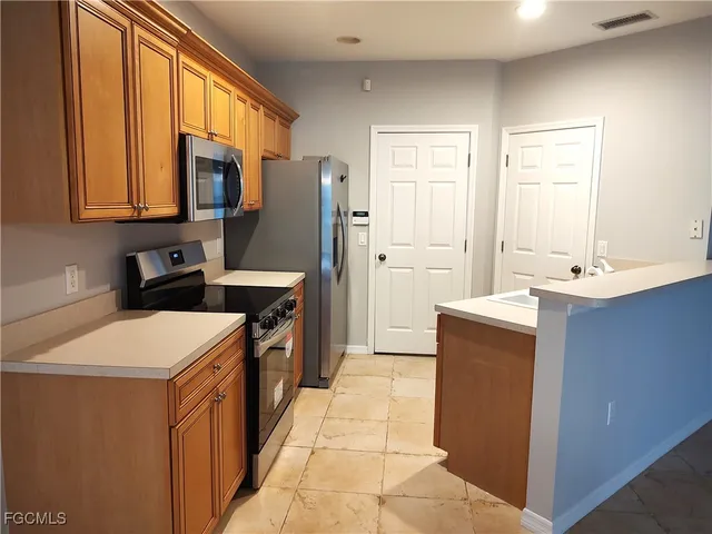 a kitchen that has a sink stainless steel appliances a counter space and a window